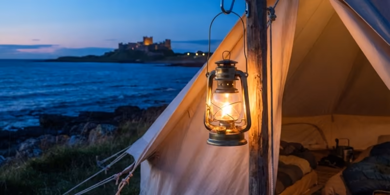 A storm lantern hanging in a bell tent doorway, the castle across the bay